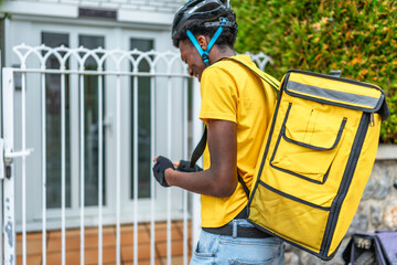 Delivery african young man at the entrance of a house