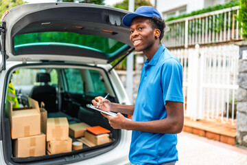 African delivery man verifying the packages on a van