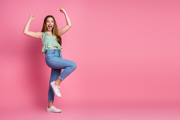 Full body portrait of pretty young girl raise fists empty space wear top isolated on pink color background