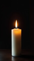 A lit candle stands against a dark background, symbolizing warmth and tranquility.