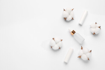 Different cosmetic products and cotton flowers on white background, flat lay. Space for text