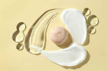 Smears of different cosmetic products on beige background, top view