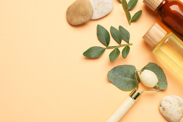 Different cosmetic products and leaves on pale orange background, flat lay. Space for text
