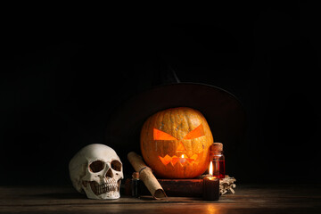 Halloween pumpkin and witch's attributes on dark background