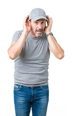 Handsome middle age hoary senior man wearing sport cap over isolated background Trying to hear both hands on ear gesture, curious for gossip. Hearing problem, deaf