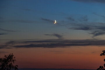 View of a waxing moon in the colourful evening sky from Friedberg towards Augsburg