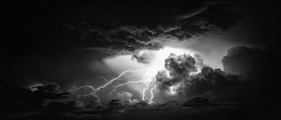 Bold black and white image of a dramatic storm with lightning bolts illuminating the sky set against a solid black background capturing power and intensity