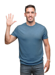 Naklejka premium Handsome young casual man showing and pointing up with fingers number five while smiling confident and happy.
