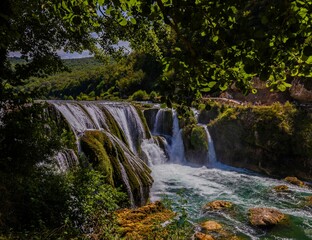 Scenic view of a waterfall surrounded by lush greenery.