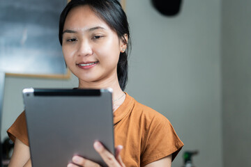 Young Woman Using Tablet in Cozy Indoor Setting