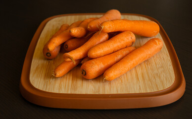 Bunch of Fresh Organic Carrots on a Wooden Chopping Board Close-Up