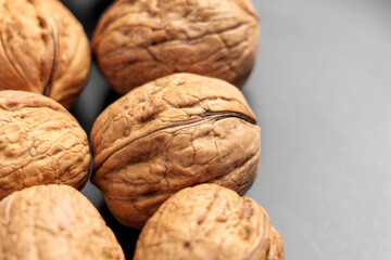 Organically grown whole walnuts in shell nuts on a luxury black ceramic plate