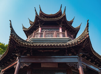 Traditional Chinese pagoda viewed from below under a clear blue sky in a serene park setting