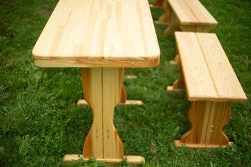 Fototapeta premium A wooden table on green grass. Empty wooden table. Furniture for relaxing outside.