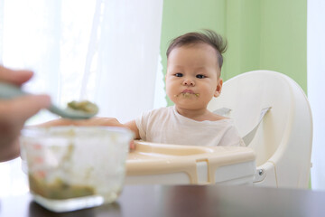 The baby is lazy to eat on the high chair