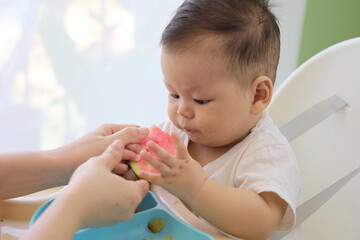 baby is eating watermelon