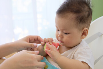 baby is eating watermelon