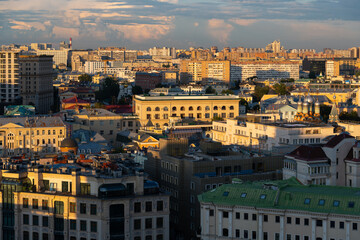 Fototapeta premium High angle panoramic cityscape of downtown district with residential, office and religious buildings at sunset in Moscow, Russia. Clouds on sky. Soft focus. Capital cities theme.