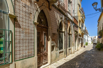 Narrow empty street in the old town Tomar in Portugal. House with typical portuguese tiles on the wall.
