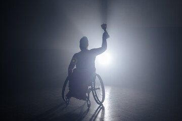 Woman with disability hoisting a trophy in the air to celebrate a sports victory and accomplishment. Success concepts.