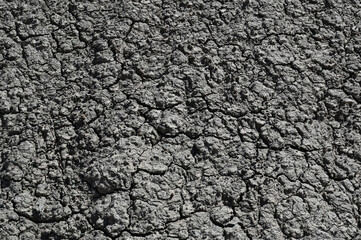 Texture and background of the dry grey stone washed out on the surface by weathering and rain - erosion of the rock.