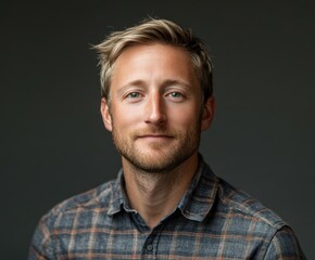 Obraz premium Portrait of a smiling man in a flannel shirt against a dark background