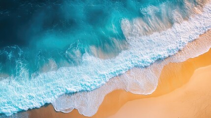 Aerial image of a brilliant blue sea on a clear, sunny day, featuring splashing waves and a sandy coastline