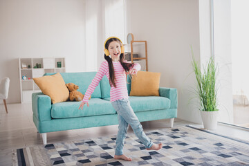 Obraz premium Photo portrait of young funny kid energetic brunette girl staying at home listen music headphones dancing alone isolated in her room