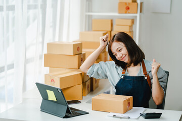 Small online business owners are very excited to be able to make sales. The seller is inspecting the parcel and packing the product before sending. Preparing packages for SME e-commerce delivery servi