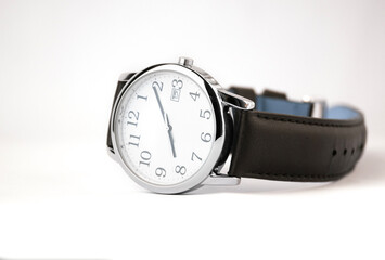 A close up of a wristwatch with a black leather strap