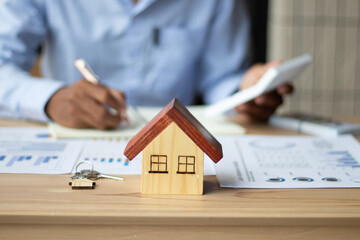 Fototapeta premium A businessman, a real estate sales representative, is analyzing the company's profits with his planned success graph.