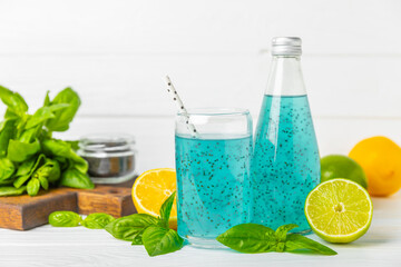 Diet detox cocktail with basil and chia seeds in a glass jar and a glass on a textured background....