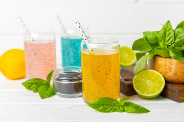 Diet detox cocktail with basil and chia seeds in a glass jar and a glass on a textured background....