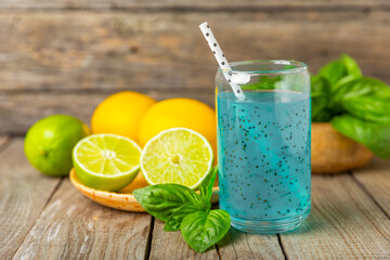 Diet detox cocktail with basil and chia seeds in a glass jar and a glass on a textured background....