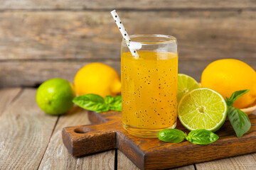 Diet detox cocktail with basil and chia seeds in a glass jar and a glass on a textured background....