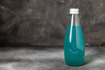Diet detox cocktail with basil and chia seeds in a glass jar and a glass on a textured background....