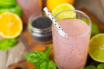 Diet detox cocktail with basil and chia seeds in a glass jar and a glass on a textured background....