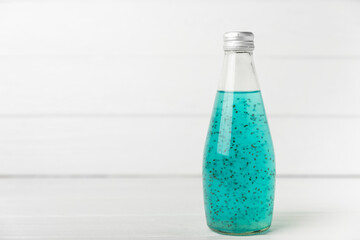 Diet detox cocktail with basil and chia seeds in a glass jar and a glass on a textured background....