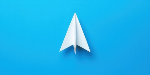 Dreaming High: Minimalist Paper Plane Symbolizing Aspirations on Blue Background