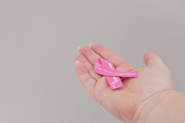 Woman holding pink ribbon.  Awareness about breast cancer patients..World Cancer Day, patient support, timely diagnosis.World Health Day. October is Breast Cancer Awareness Month in Sweden
