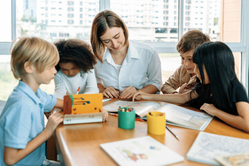Teacher is teaching student about lesson from the books in the classroom, the children are happy....