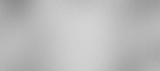 Abstract grainy silver metallic background texture is illuminated with a subtle light reflection