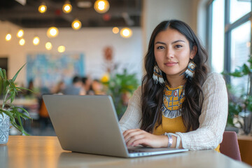 Native American female entrepreneur in modern office working on laptop, remote job and education