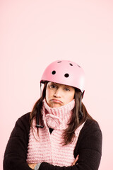 Woman, studio and arms crossed with bicycle helmet for transportation and riding on pink background. Female person, fashion and with nervous or scared on portrait on safety gear for bike or cycling