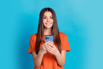 Photo portrait of attractive teen woman lhold device dressed stylish orange clothes isolated on...