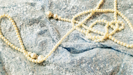 Pearl decoration on shiny blue fabric. Fashion background design, photography. Textile, fabric template,  modern new