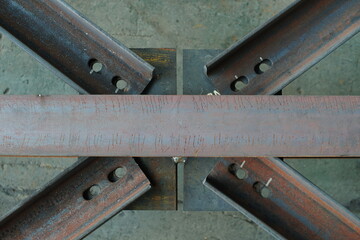 Connecting metal beams with a crosspiece with oval holes. Strength and stability of structures, as well as to compensate for possible deformations or thermal expansion of the metal.