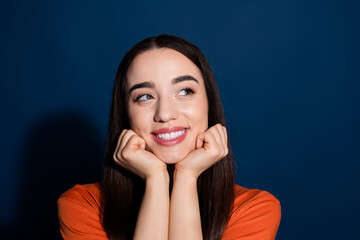 Photo of lovely pretty cute woman wear orange trendy clothes touch chin look empty space isolated on dark blue color background