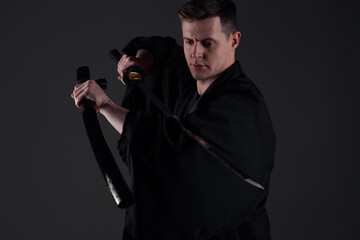 Samurai ninja warrior in kimono in attack pose with katana sword. dark room. sword shine. fighter. japanese culture