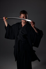 Samurai ninja warrior in kimono in attack pose with katana sword. dark room. sword shine. fighter. japanese culture